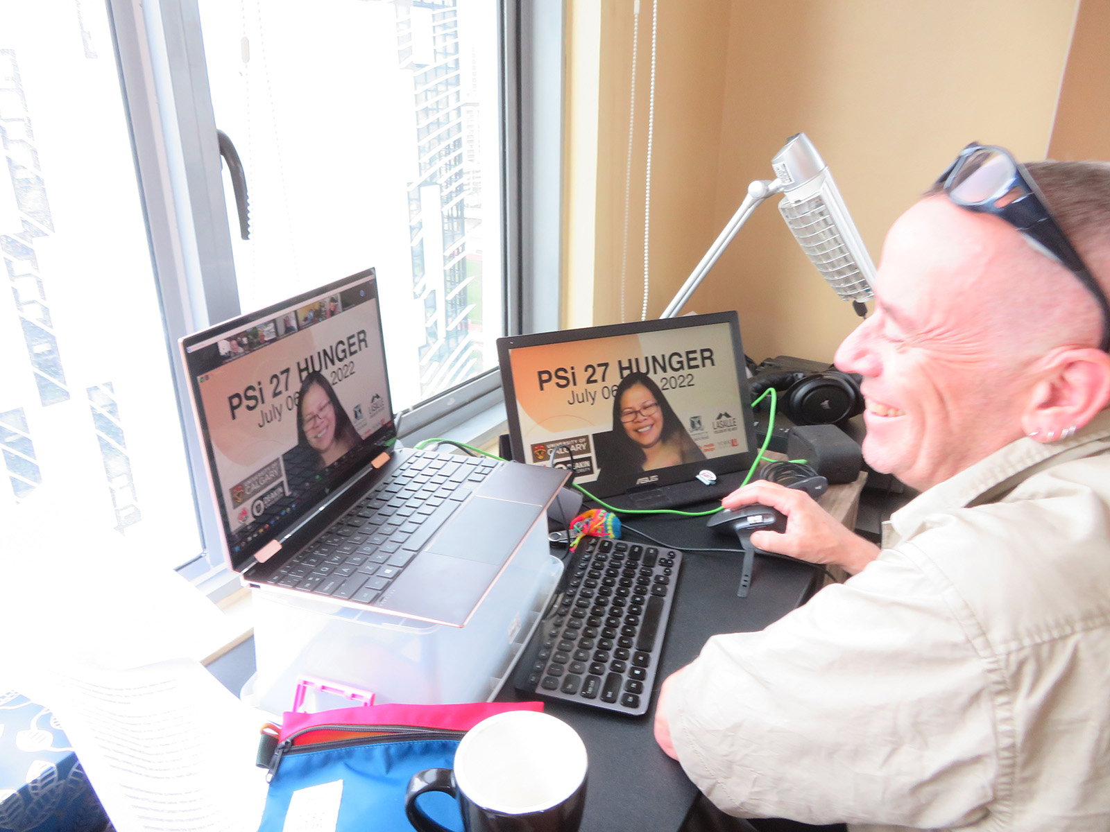 laptop with Zoom meeting in front of window showing city skyline