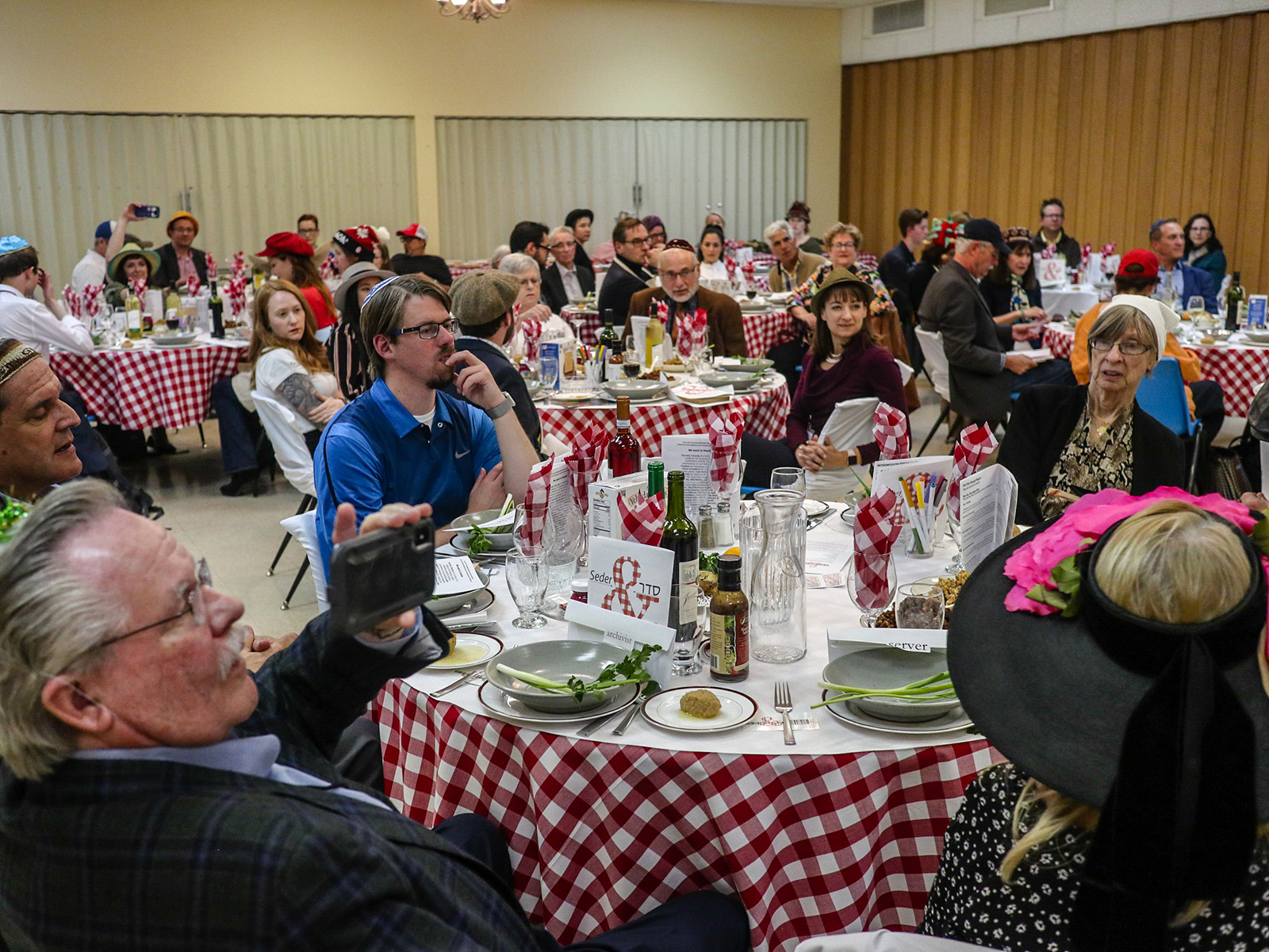 groups of people seated at gingham-covered tables