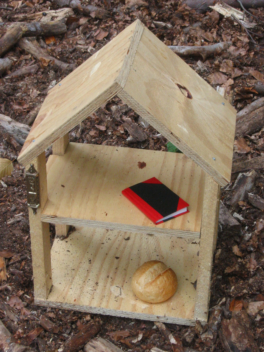 small wooden house with book and bread<
