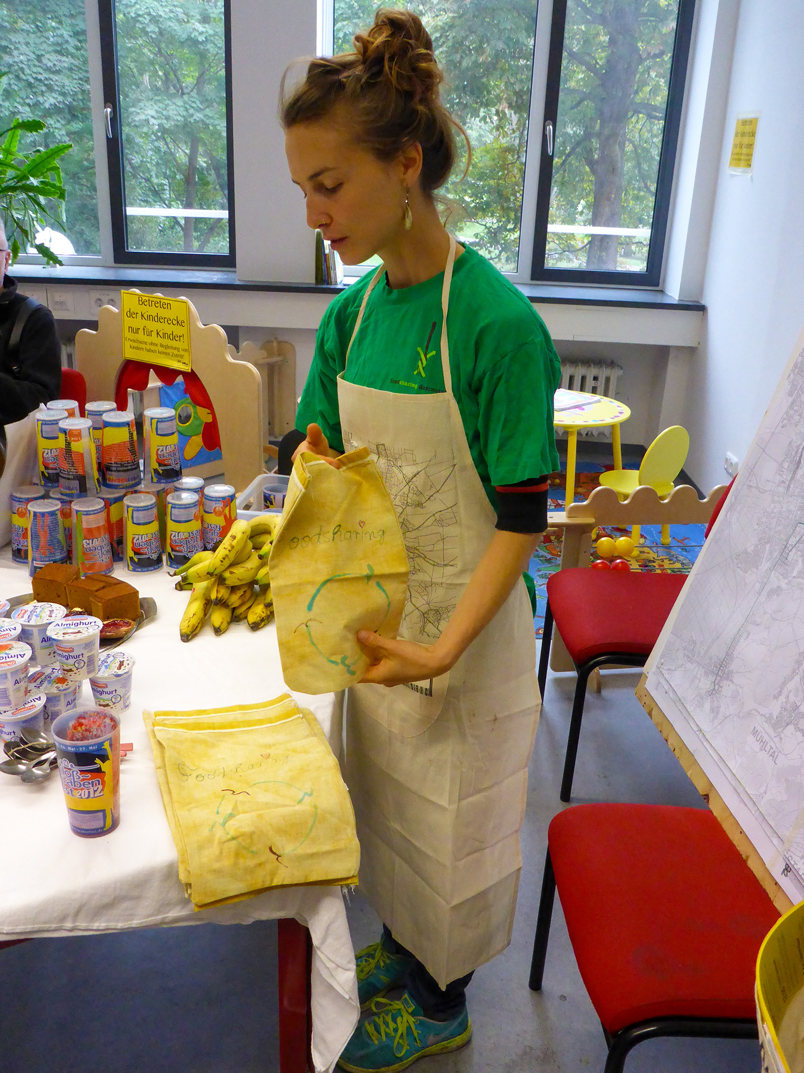 woman in apron at table holding food