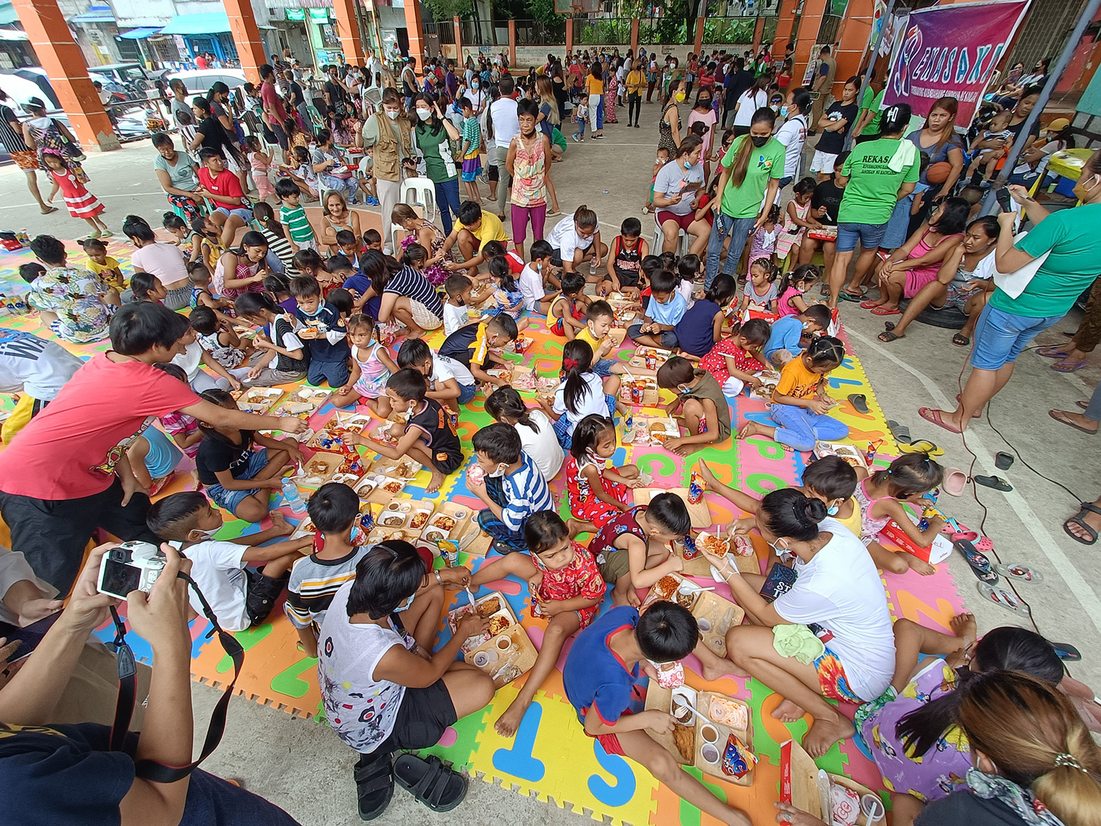 large gathering of children eating lunch
