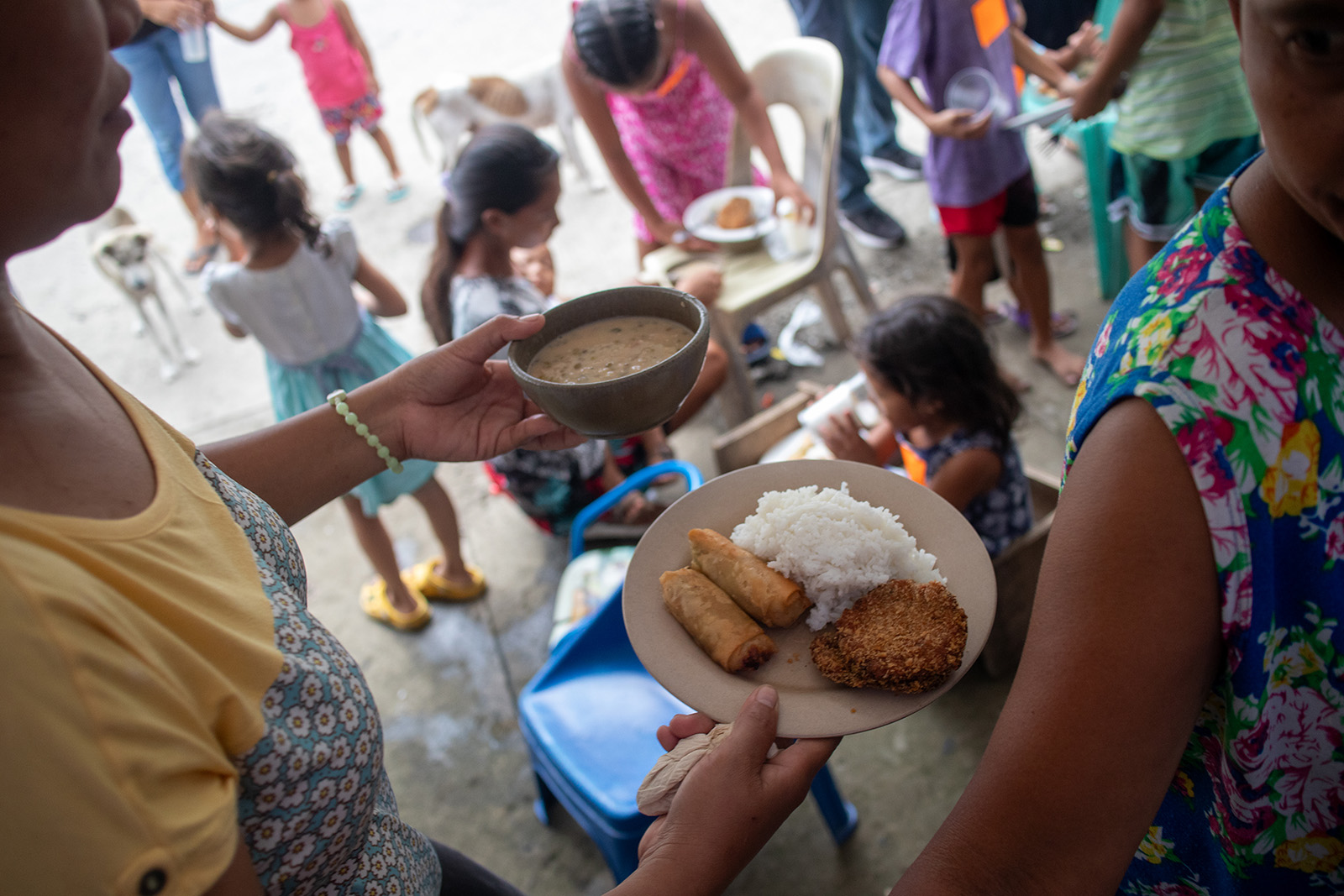 hands giving/receiving soup in bowls