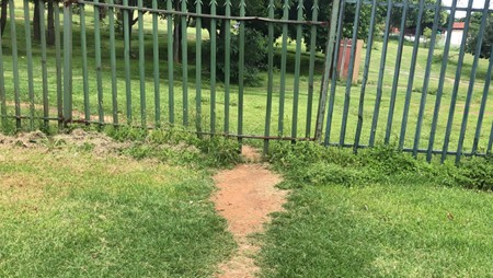 Footpath through grass leading through a gate